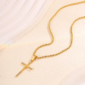 Close-up of a gold-plated stainless steel cross pendant with sparkling rhinestones