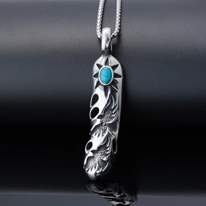 Vintage stainless steel feather pendant necklace with turquoise inlay on a black background