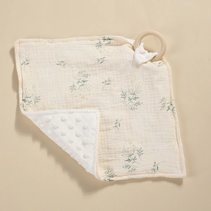 Detalle de manta de apego para bebé con muselina floral y minky de puntos