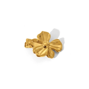 Detailansicht einer goldenen Metall-Haarklammer in Blumenform mit glatter Oberfläche