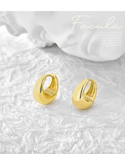 Close-up of polished 18K gold-plated U-shaped hoop earrings on white textured paper
