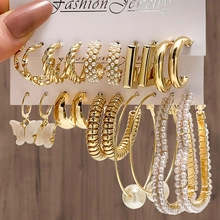 Detail of 9-piece gold earring set featuring butterfly pendants and imitation pearls