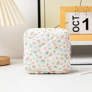 Detailed shot of quilted floral sanitary bag on a desk with aesthetic lifestyle background