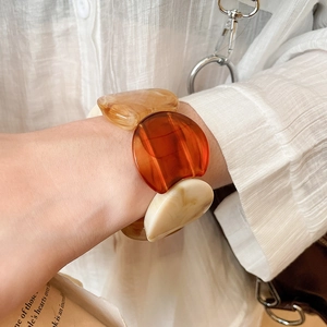 Detailed view of large acrylic resin link bracelet in amber and cream tones