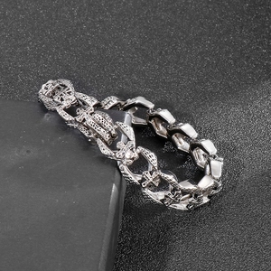 Close-up of gothic stainless steel cross link bracelet on black decorative stone