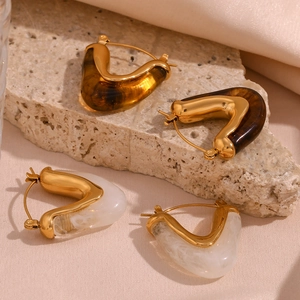 Detail of 18K gold plated stainless steel V-shaped earrings with amber and marble resin