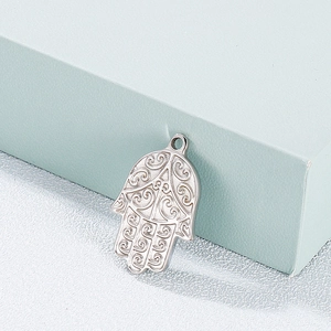 Detailed view of silver stainless steel Hamsa Hand pendant with intricate swirl patterns