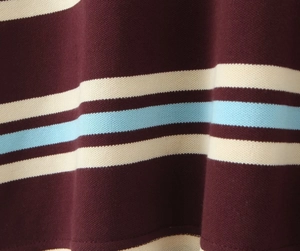Close-up of piqué fabric texture with burgundy, cream, and light blue stripes