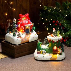 Detail of Christmas resin house with LED lights and festive snow painted decoration