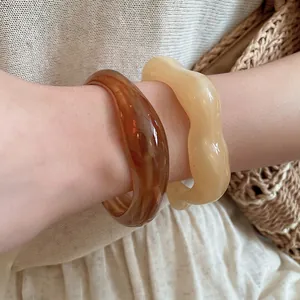 Minimalist irregular wavy acrylic cuff bracelets in amber brown and cream beige tones