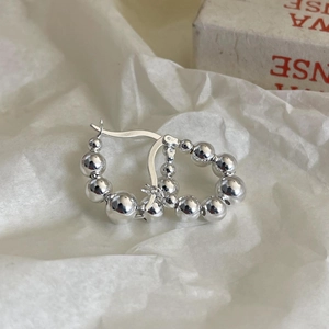 Detailed view of S925 sterling silver beaded hoop earrings on a soft white paper background