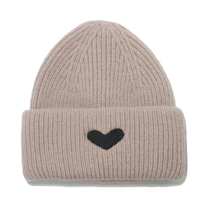Cozy beige knit beanie for women with a black heart patch and ribbed winter texture