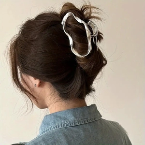 Irregular silver cloud claw clip shown on model's hair with minimalist metallic finish