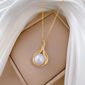 Elegant gold fishtail necklace with pearl and rhinestones displayed on silk fabric
