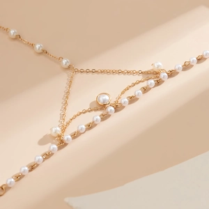 Detailed view of gold chain bracelet with pearls and circular rhinestone setting