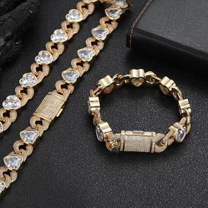 Detailopname van 12mm gouden Cubaanse schakelarmband en ketting met hartvormige zirkoon