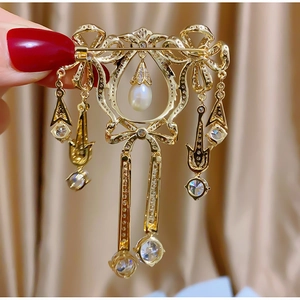 Détail du fermoir de sécurité d'une broche vintage dorée avec perles et zircons