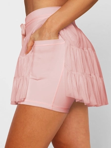 Detail of pink tiered mesh sports skirt with built-in shorts and functional side pocket