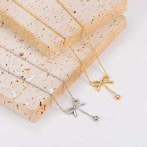 Bow tie necklace with tassels and zirconia stones in gold and silver finish