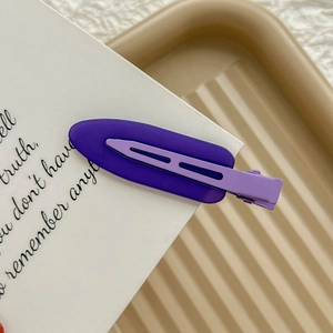 Close-up of purple two-tone seamless metal hair clip on decorative display card