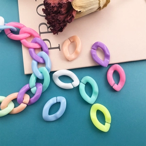 Colorful acrylic U-shaped chain links assembly and loose pieces on a teal surface