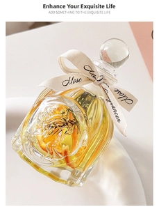 Macro view of clear glass diffuser bottle with rose petals and botanicals inside