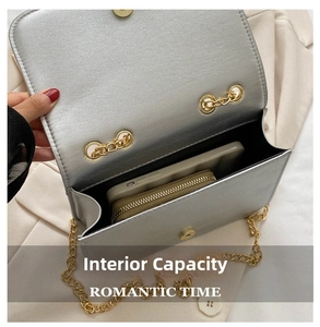 Silver metallic shoulder bag with gold chain showing internal capacity for phone and wallet