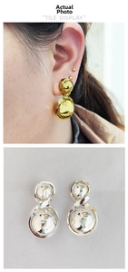 Macro detail of twisted double hoop geometric earrings in gold and silver finish