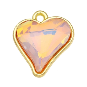Macro shot of heart-shaped pendant with orange crystal and gold metal frame