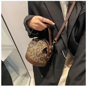 Close-up of a vintage brown bucket bag with leopard pattern and gold metal hardware