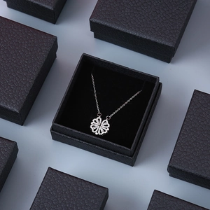 Detail showing clover heart necklace in an open premium black textured jewelry gift box