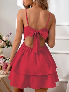 Detail of red backless summer dress featuring a large bow tie and layered A-line skirt