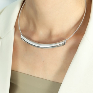 Minimalist silver curved bar pendant necklace on female model in white blazer