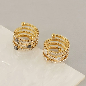 Macro detail of 18K gold spiral rings with black and white zircon heart inlays