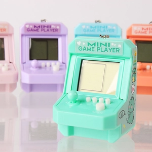 Mini retro arcade game player with joystick and colorful keychain variety in background