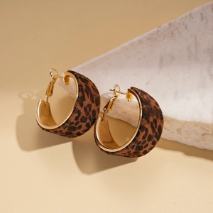 Detailed view of flocked leopard print C-shape hoop earrings with gold inner lining