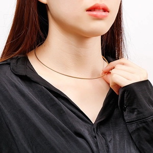 Close-up of golden sleek snake bone chain necklace on neck showing elegant minimalist style