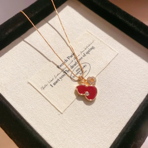 Close-up of red enamel gourd pendant and gold coin charm on elegant rose gold necklace chain