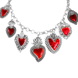 Detailed close-up of silver chain necklace with multiple red enamel sacred heart charms