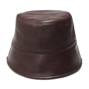 Macro detail of wine red leather bucket hat showing premium grain texture and fine stitching