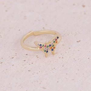 Macro shot of gold butterfly ring featuring multi-colored micro-inlaid cubic zirconia crystals