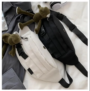 Detail of canvas chest bags in black and beige with adjustable nylon straps and buckles