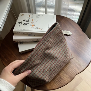 Detail of red and green vintage plaid tweed cosmetic bag with soft texture and zipper