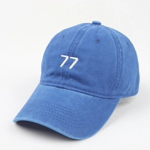 Close-up of white 77 embroidery on vintage blue washed cotton baseball cap texture