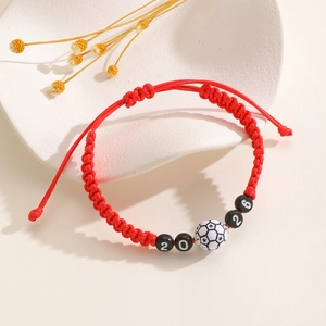 Macro shot of 2026 soccer commemorative red woven bracelet with adjustable sliding knot