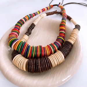 Bohemian double-layered necklaces with colorful coconut shell and wood beads on ceramic tray