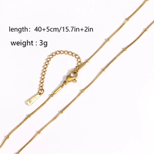 Detail of 18k gold plated snake chain necklace with beads and lobster clasp on white background