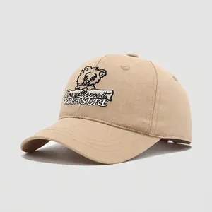Detailed embroidery of a cartoon bear and Pleasure text on a beige kids' cotton cap