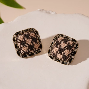 Detail of square houndstooth fabric earrings with rhinestone trim and gold accents
