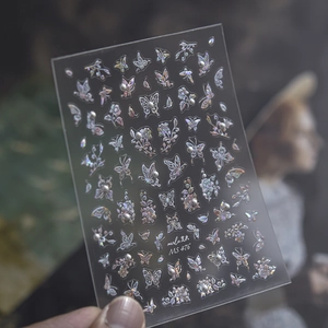 Close-up of MS 476 nail stickers featuring holographic butterflies, flowers, and tiny pearls
